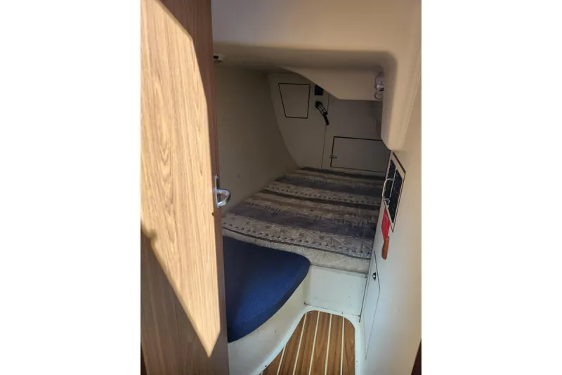 Slide: The Image of Interior cabin of a 2005 Hunter 27 sailboat with a cozy bed and wooden flooring. - 28