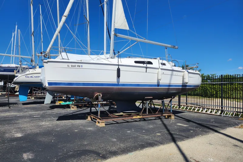 Slide: The Image of 2005 Hunter 27 sailboat on dry dock under clear blue sky. - 34