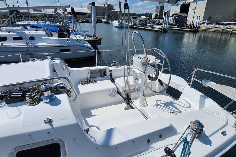 Slide: The Image of Hunter 27 sailboat from 2005 docked at marina, featuring steering wheel and rigging. - 6