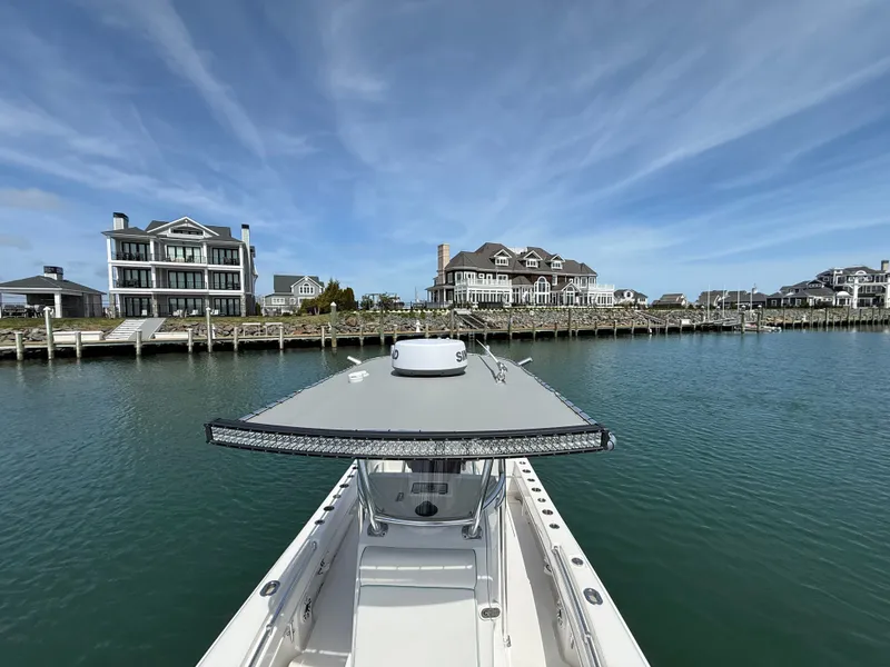 Slide: The Image of Contender 25 Tournament 2021 boat near coastal homes on calm water. - 11