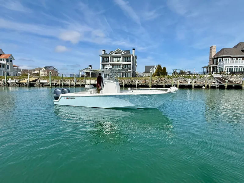 Slide: The Image of 2021 Contender 25 Tournament boat near coastal homes. - 2