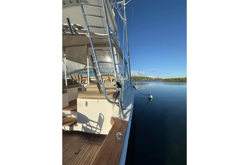 Slide: The Image of 2003 Cabo 35 Express yacht docked on calm water under clear blue sky. - 10
