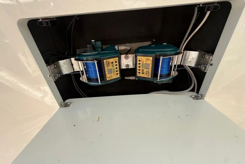Slide: The Image of Fishing reel setup inside a 2003 Cabo 35 Express boat compartment. - 17