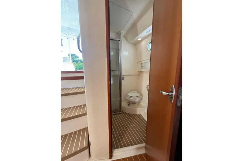 Slide: The Image of Bathroom interior of 2003 Cabo 35 Express boat with wooden flooring and compact design. - 27