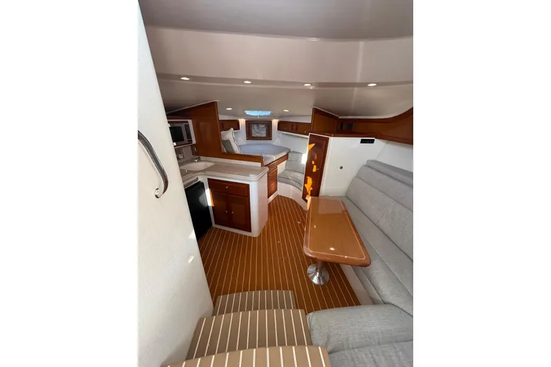 Slide: The Image of Interior of 2003 Cabo 35 Express yacht with wood accents and cozy seating area. - 28