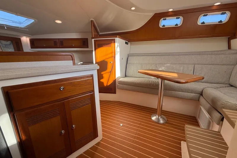 Slide: The Image of 2003 Cabo 35 Express yacht interior with wooden cabinetry and cozy seating area. - 30