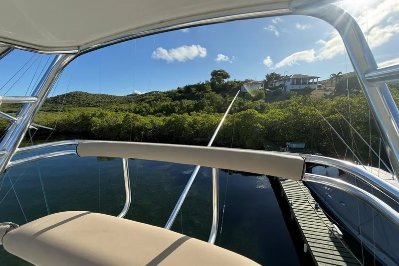 Slide: The Image of View from a 2003 Cabo 35 Express boat overlooking lush greenery and a dock. - 37