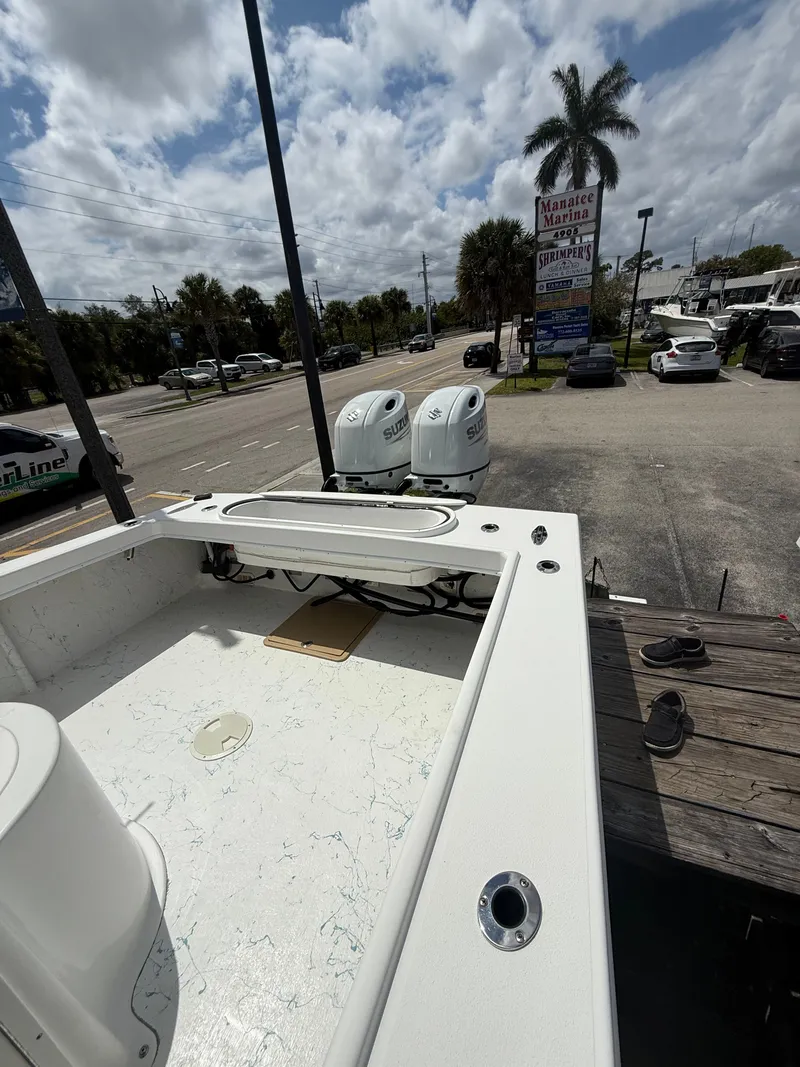 Slide: The Image of 2021 C-Hawk Center Console 29 boat with Suzuki engines parked outdoors. - 12