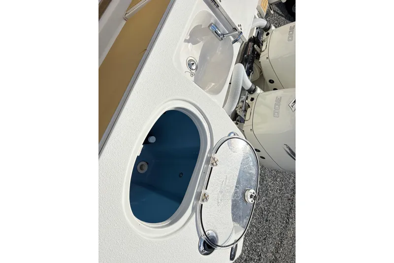 Slide: The Image of 2017 Carolina Skiff Sea Chaser 27 HFC boat with open storage compartment and dual engines. - 12