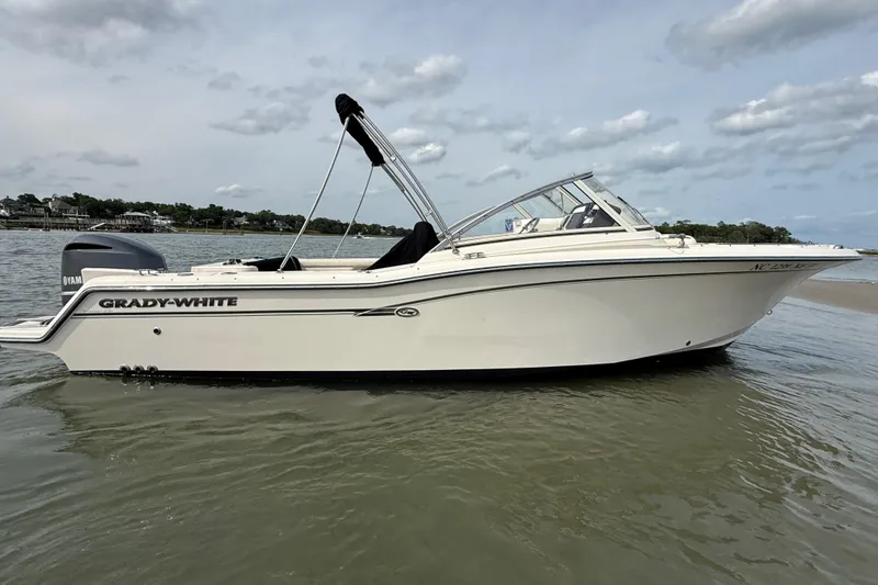 Slide: The Image of 2017 Grady-White Freedom 235 boat on calm water under a cloudy sky. - 12