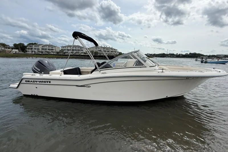 Slide: The Image of 2017 Grady-White Freedom 235 boat on calm water, showcasing sleek design and Yamaha engine. - 20