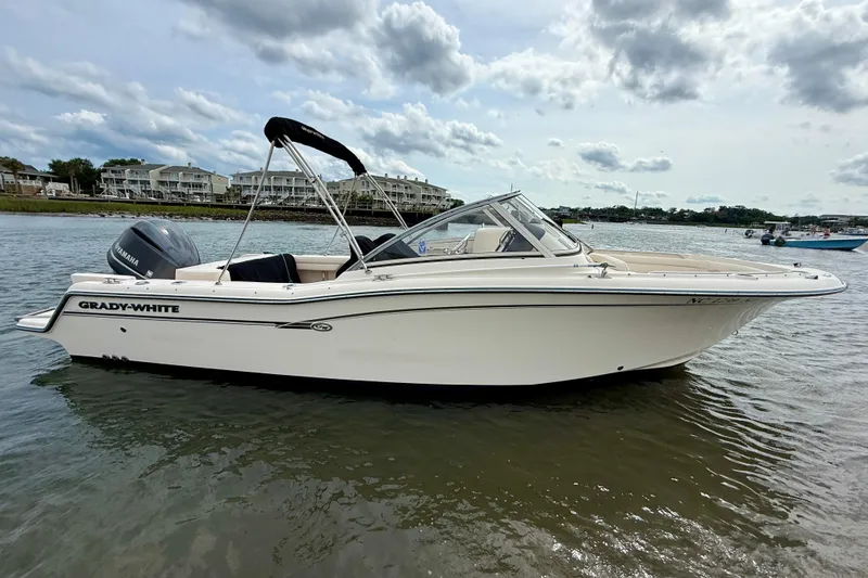 Slide: The Image of 2017 Grady-White Freedom 235 boat on water, side view, under cloudy sky. - 21
