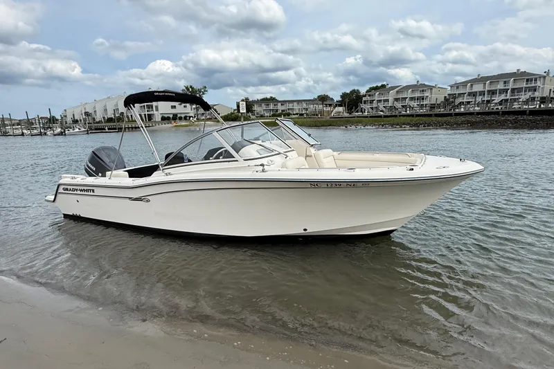 Slide: The Image of 2017 Grady-White Freedom 235 boat on calm water near shoreline. - 22