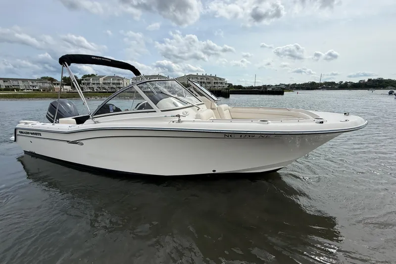 Slide: The Image of 2017 Grady-White Freedom 235 boat on calm water, showcasing sleek design and spacious seating. - 23