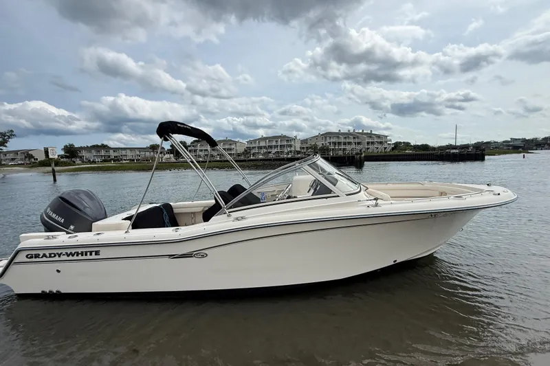 Slide: The Image of 2017 Grady-White Freedom 235 boat on calm water, cloudy sky background. - 3