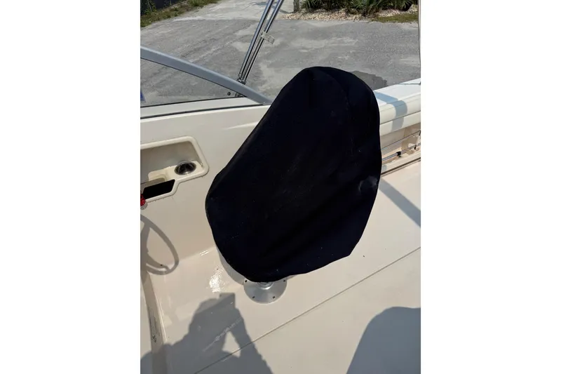 Slide: The Image of 2017 Grady-White Freedom 235 boat seat with black cover, dockside view. - 30