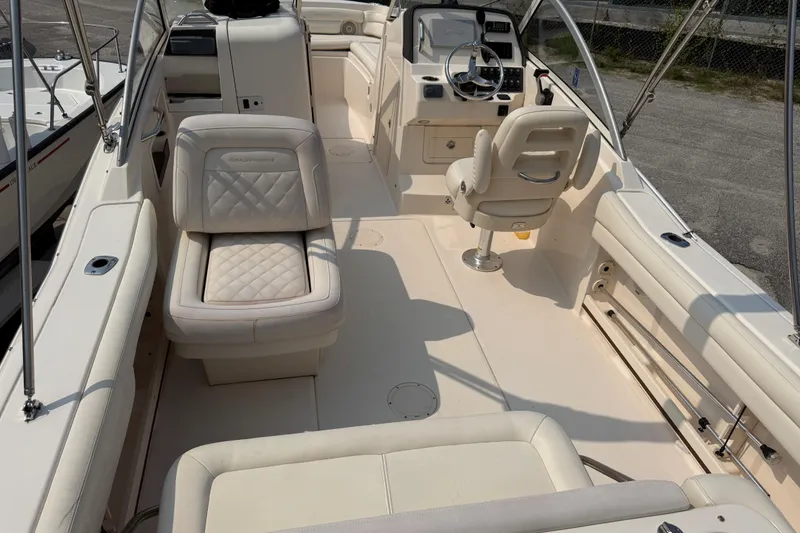 Slide: The Image of 2017 Grady-White Freedom 235 boat interior with white seating and steering console. - 33