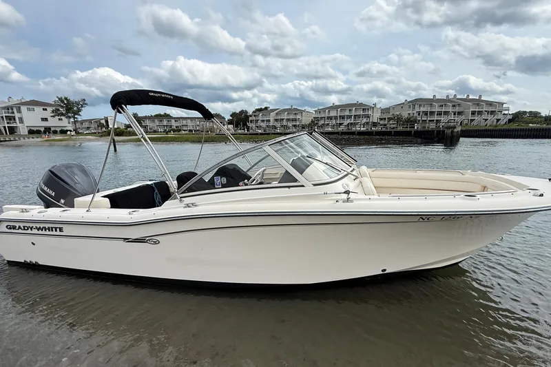 Slide: The Image of 2017 Grady-White Freedom 235 boat on calm water, with residential buildings in the background. - 4