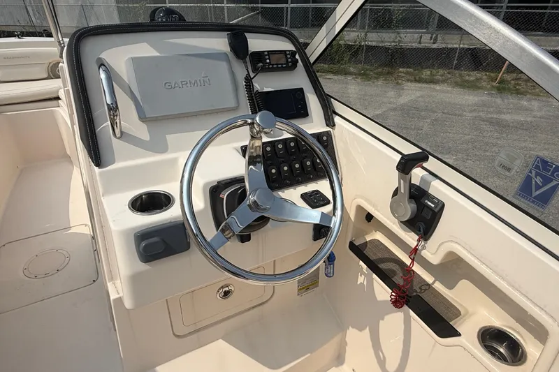 Slide: The Image of 2017 Grady-White Freedom 235 boat helm with Garmin navigation system and steering wheel. - 43