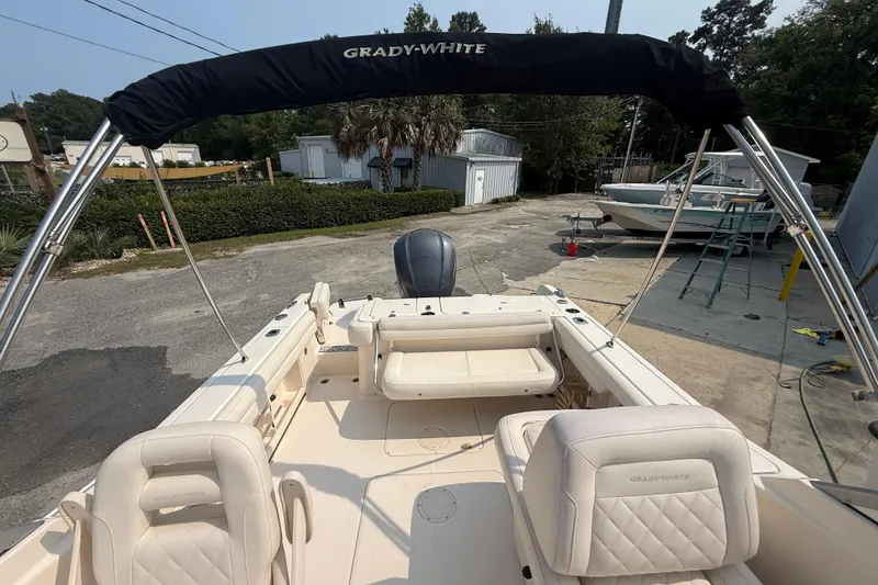 Slide: The Image of 2017 Grady-White Freedom 235 boat interior with seating and canopy, parked outdoors. - 49