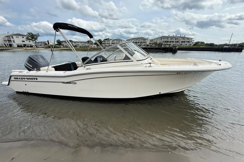 Slide: The Image of 2017 Grady-White Freedom 235 boat docked on calm water near residential buildings. - 5