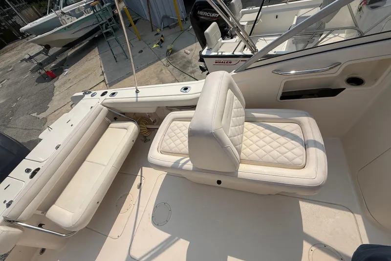Slide: The Image of 2017 Grady-White Freedom 235 boat interior with cushioned seating and fishing rod holders. - 50
