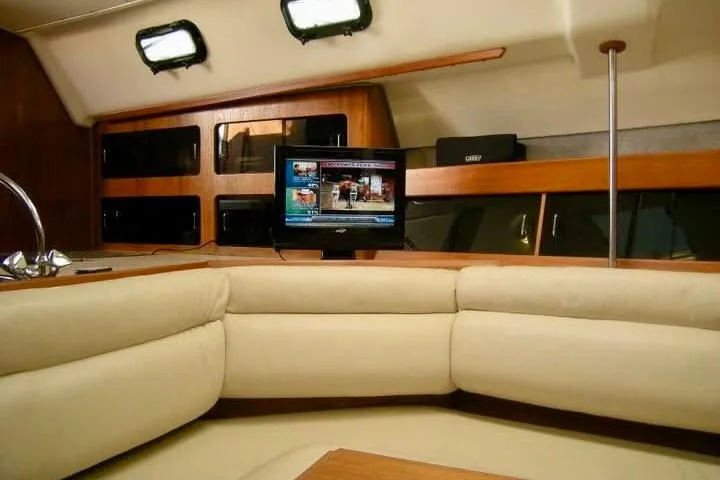 Slide: The Image of Interior of a 1987 Hunter Legend 35 yacht with cozy seating and a mounted TV. - 10