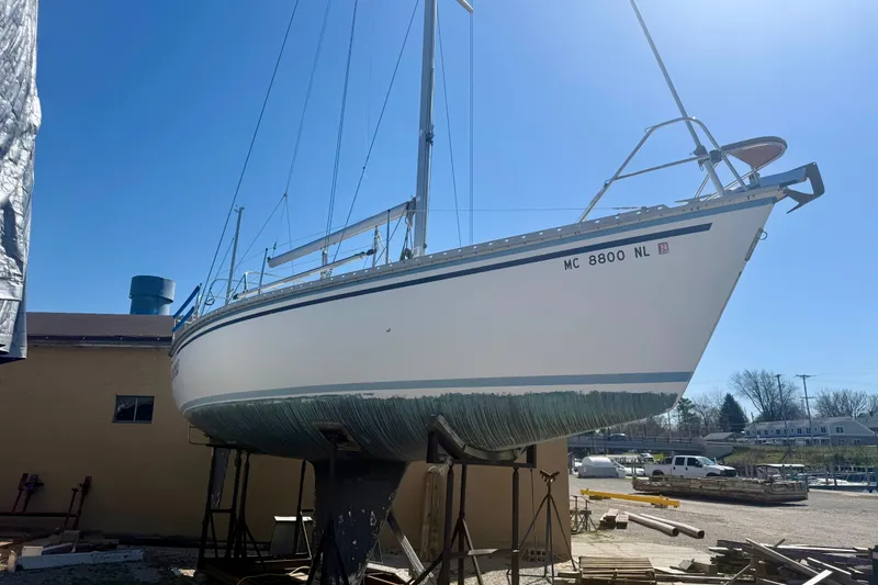 Slide: The Image of 1987 Hunter Legend 35 sailboat on dry dock under clear blue sky. - 3