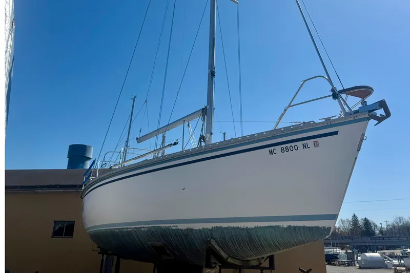 Slide: The Image of 1987 Hunter Legend 35 sailboat on dry dock under clear blue sky. - 4