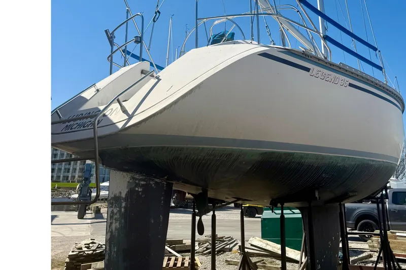 Slide: The Image of 1987 Hunter Legend 35 sailboat on stands, viewed from the stern in a marina setting. - 6