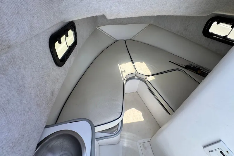 Slide: The Image of Interior cabin of a 1991 Boston Whaler 21 Conquest R boat, featuring cushioned seating. - 11