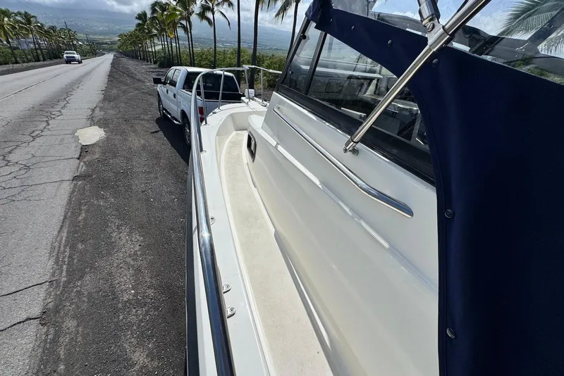Slide: The Image of 1991 Boston Whaler 21 Conquest R boat on trailer beside a scenic road. - 13
