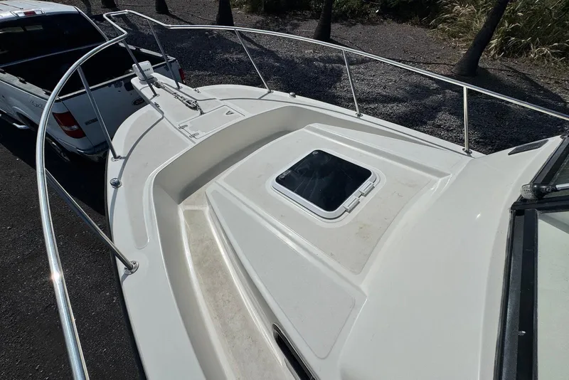 Slide: The Image of 1991 Boston Whaler 21 Conquest R boat deck with railing, parked beside a white truck. - 14