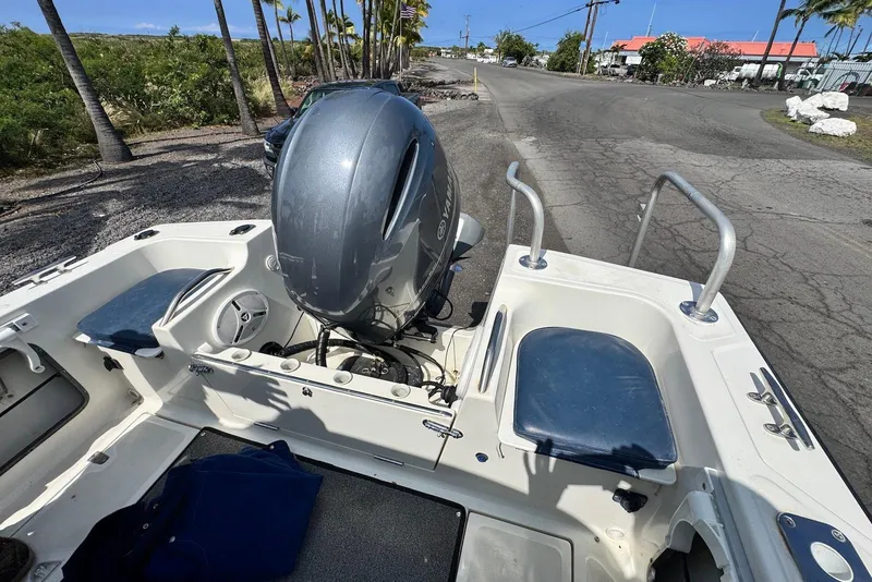 Slide: The Image of 1991 Boston Whaler 21 Conquest R boat with Yamaha outboard motor, parked on a sunny road. - 15