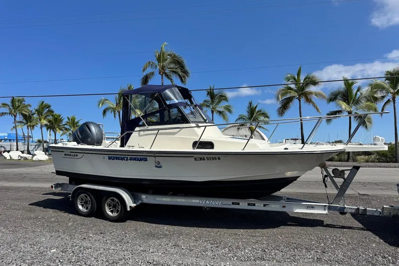 Slide: The Image of 1991 Boston Whaler 21 Conquest R boat on trailer, palm trees in background. - 4