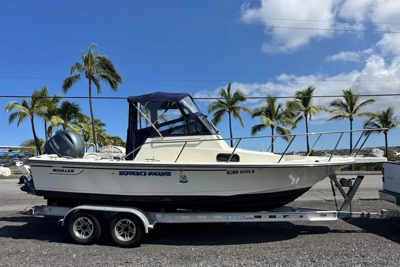 Slide: The Image of 1991 Boston Whaler 21 Conquest R boat on trailer, palm trees in background. - 5