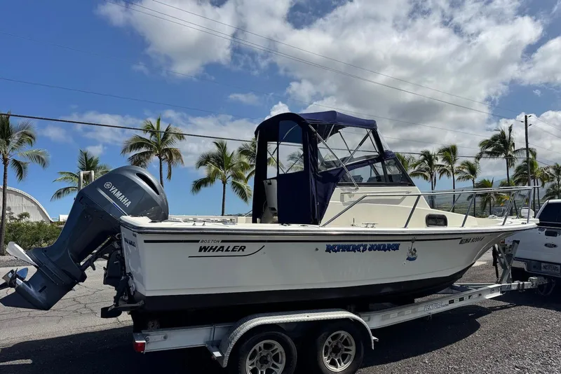 Slide: The Image of 1991 Boston Whaler 21 Conquest R boat on trailer, with Yamaha outboard motor, under blue sky. - 6