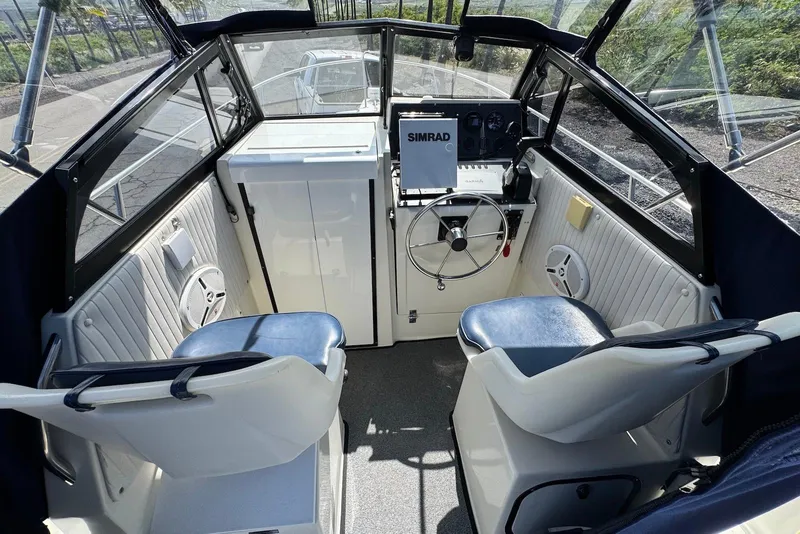 Slide: The Image of Interior of a 1991 Boston Whaler 21 Conquest R boat with steering wheel and seating. - 9