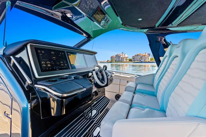 Slide: The Image of 2024 Cigarette 42' Auroris luxury boat interior with advanced dashboard and plush seating. - 12