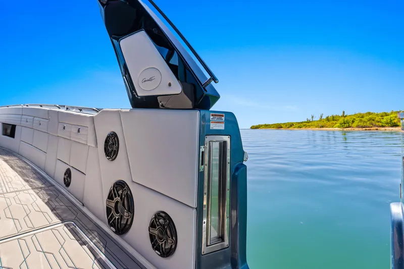 Slide: The Image of 2024 Cigarette 42' Auroris boat with speakers, open hatch, and scenic water view. - 19
