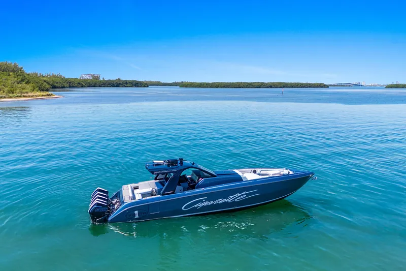 Slide: The Image of 2024 Cigarette 42' Auroris boat on serene blue water under clear sky. - 3