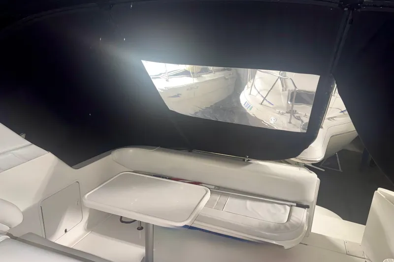 Slide: The Image of Interior of a 1996 Sea Ray boat with white seating and a small table. - 13
