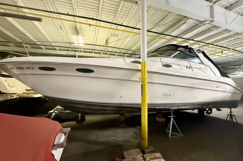 Slide: The Image of 1996 Sea Ray boat stored indoors, elevated on stands, under a metal roof. - 17
