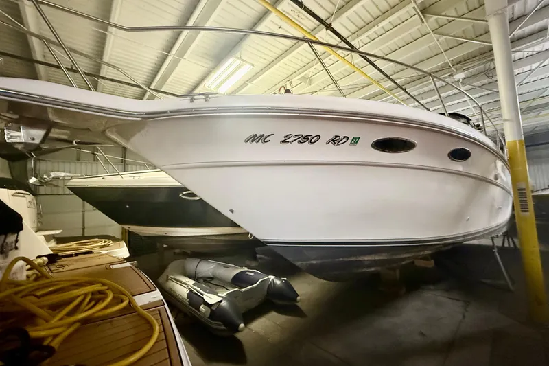 Slide: The Image of 1996 Sea Ray boat stored indoors, featuring sleek white hull and visible registration number. - 18