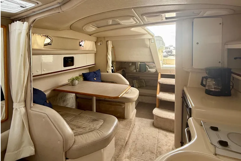 Slide: The Image of Interior of a 1996 Sea Ray boat featuring a cozy dining area and kitchenette. - 20