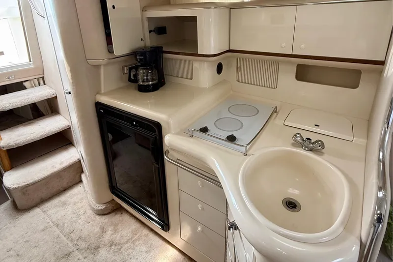 Slide: The Image of 1996 Sea Ray boat kitchen with sink, stove, fridge, and coffee maker. - 21