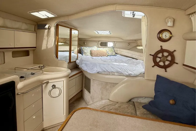 Slide: The Image of Interior of a 1996 Sea Ray boat featuring a cozy cabin with bed and kitchenette. - 23
