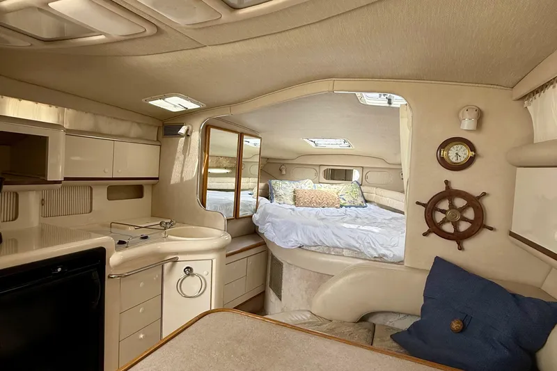 Slide: The Image of Interior of a 1996 Sea Ray boat featuring a cozy cabin with bed and kitchenette. - 24