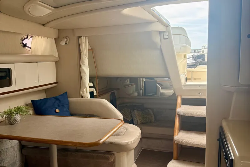 Slide: The Image of Interior of a 1996 Sea Ray boat featuring a cozy dining area and stairs. - 26