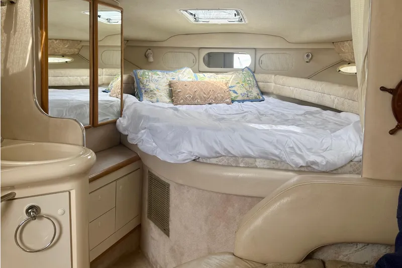 Slide: The Image of 1996 Sea Ray boat interior with cozy bed and mirrored cabinet. - 27